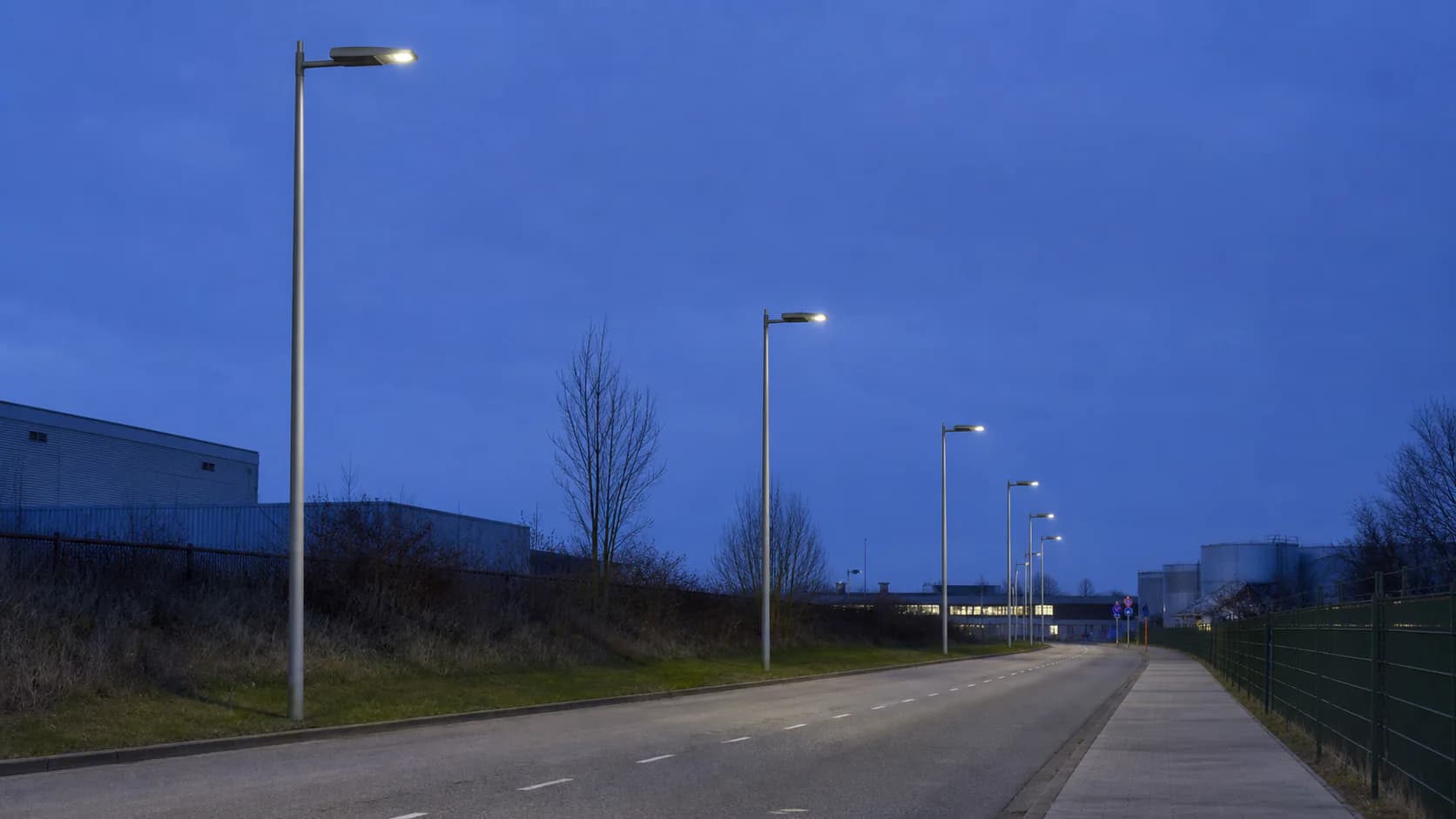 Real remote road with solar poles, open horizon, panel orientation and road geometry visible in one frame; choose a representative site rather than a tropical stock image.