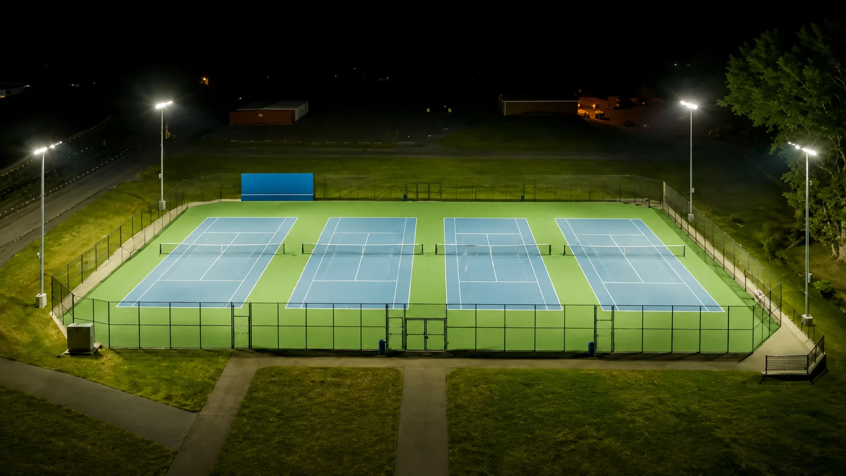 Sports field lighting illuminating an outdoor pitch at night.